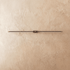 Clérachic ultra-slim linear wall light switched off, a black aluminium bar with gold end caps on textured plaster.