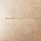 Clérachic ultra-slim linear wall light in brushed gold, with a fine line of warm light across a limewashed wall.