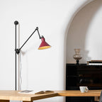 Close view of the black jointed arm and the silver-toned clamp on this Clérachic wall light, with the red shade just below.