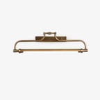A Clérachic slim wall light in aged brass on a plain white backdrop, its curved arm and glowing tube seen straight on.