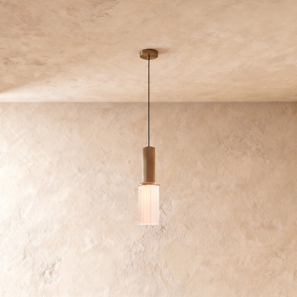 Clérachic slim ribbed glass pendant glowing softly beneath a fluted brass-toned top, hung from a round canopy