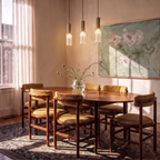 Clérachic three slim ribbed glass pendants with brass-toned tops hung at varied heights above a walnut dining table