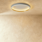 Clérachic grey round ceiling light with a glowing acrylic ring and a brushed gold inner wall, flush on limewash plaster.