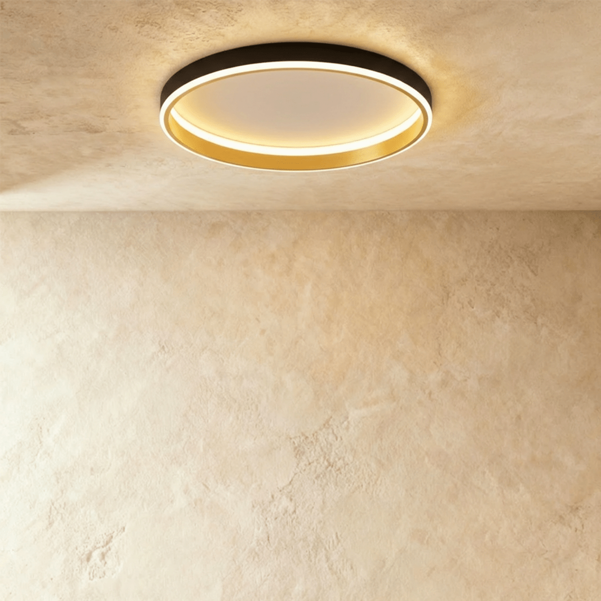 Clérachic black round ceiling light with a glowing acrylic ring and a brushed gold inner wall, flush on limewash plaster.