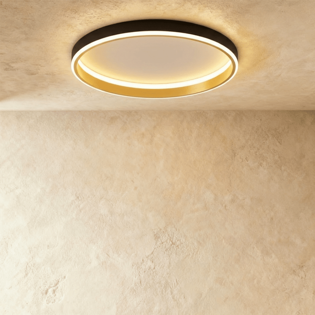 Clérachic black round ceiling light with a glowing acrylic ring and a brushed gold inner wall, flush on limewash plaster.