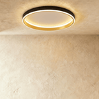 Clérachic black round ceiling light with a glowing acrylic ring and a brushed gold inner wall, flush on limewash plaster.