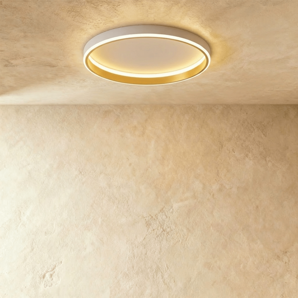 Clérachic white round ceiling light with a glowing acrylic ring and a brushed gold inner wall, flush on limewash plaster.