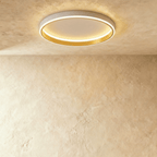 Clérachic white round ceiling light with a glowing acrylic ring and a brushed gold inner wall, flush on limewash plaster.
