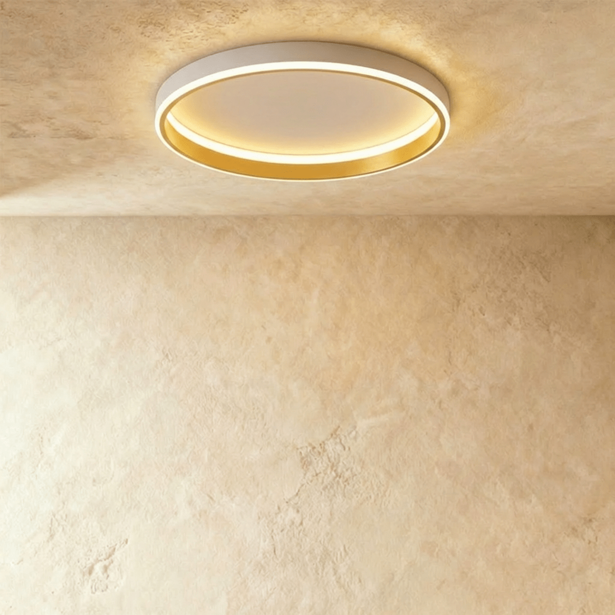 Clérachic white round ceiling light with a glowing acrylic ring and a brushed gold inner wall, flush on limewash plaster.