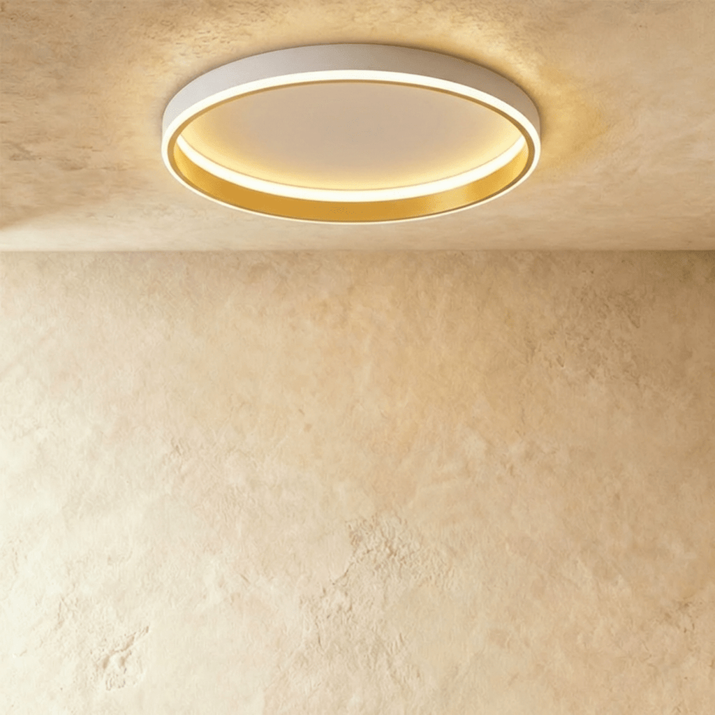 Clérachic white round ceiling light with a glowing acrylic ring and a brushed gold inner wall, flush on limewash plaster.