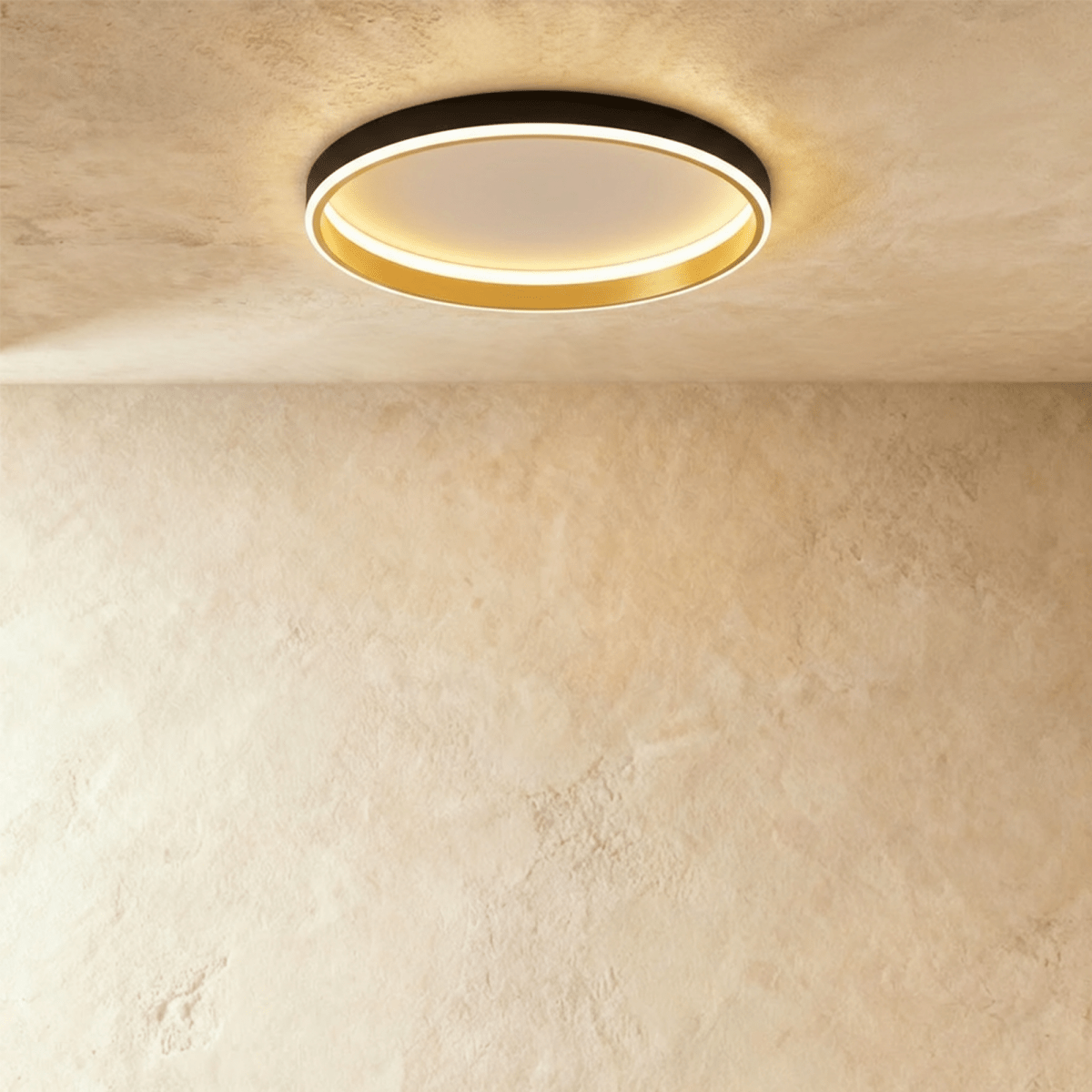 Clérachic black round ceiling light with a glowing acrylic ring and a brushed gold inner wall, flush on limewash plaster.