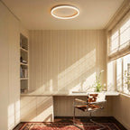 Clérachic slim white round ceiling light over a home office desk with striped wallpaper, a cowhide chair and sunlit blinds.