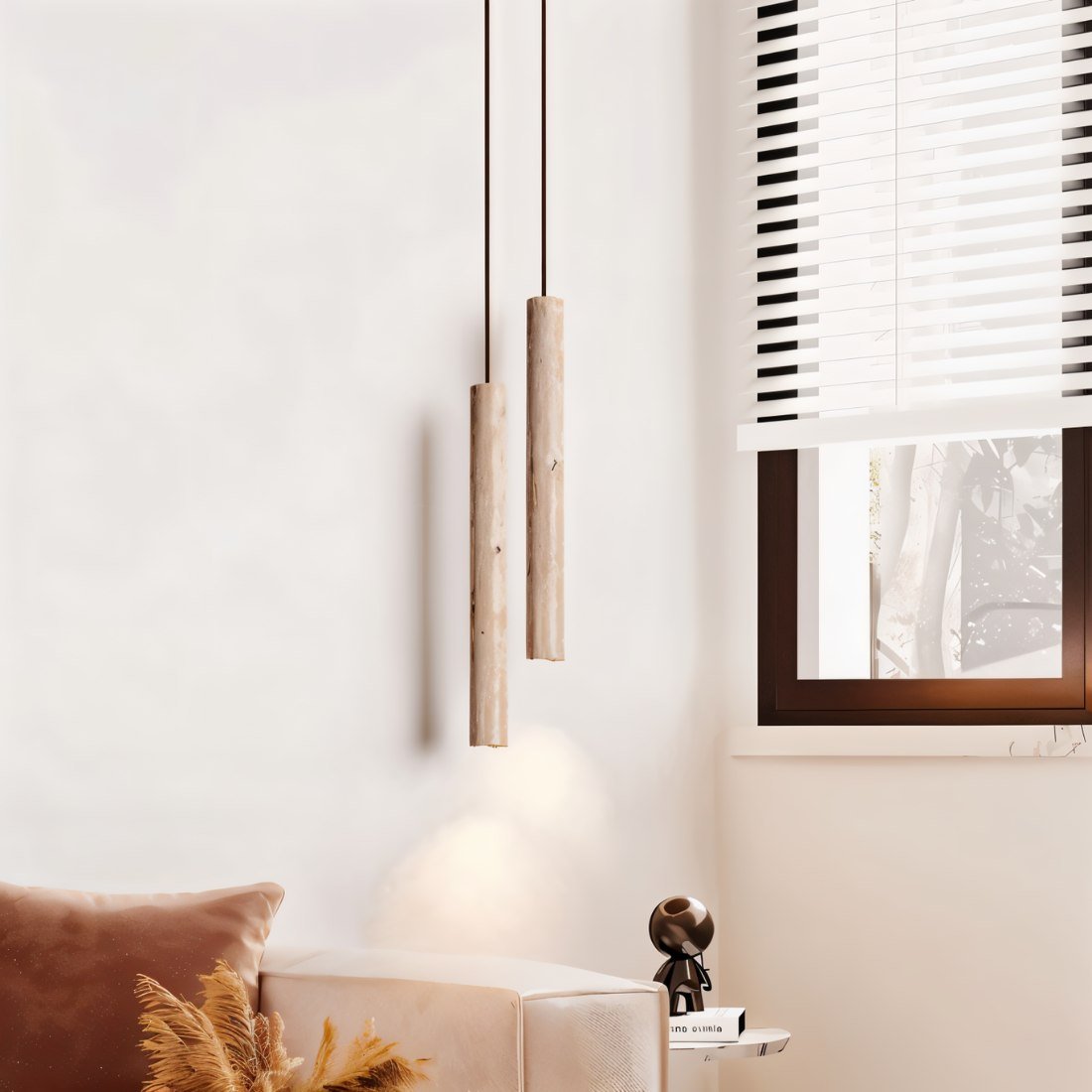 Clérachic two slim stone-look cylinder pendants at different heights beside a sofa, window blind and side table.