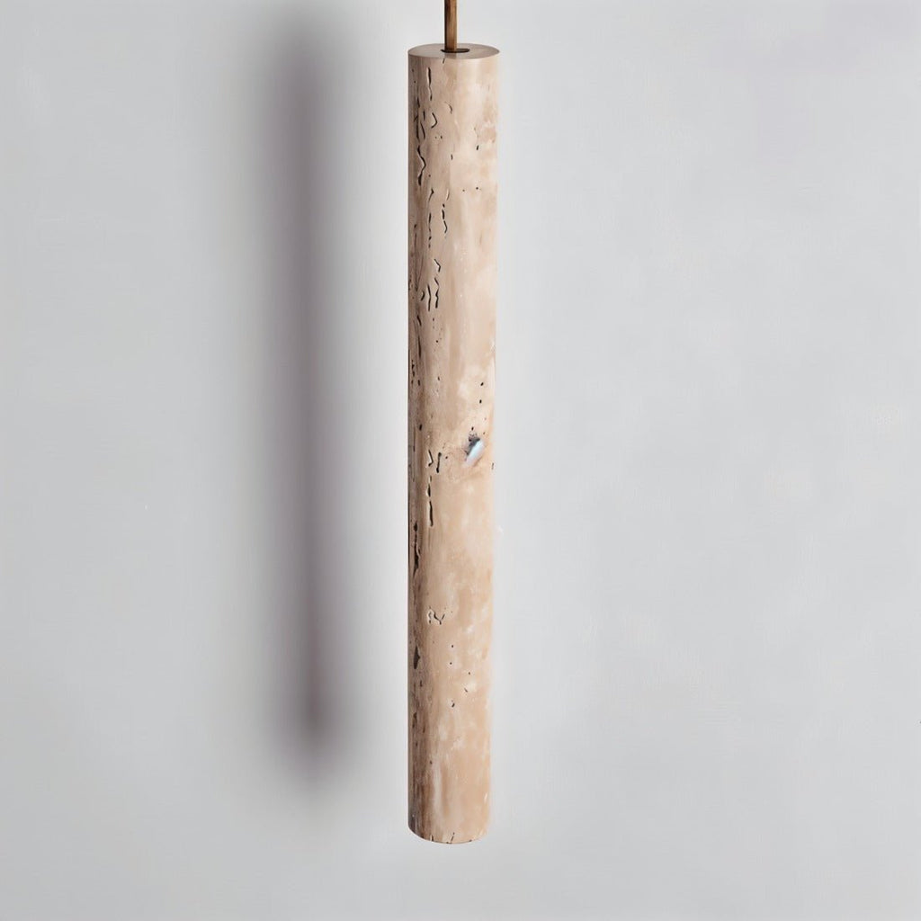 Clérachic close view of a slim travertine-look cylinder pendant showing its pitted, natural stone texture on a grey wall.