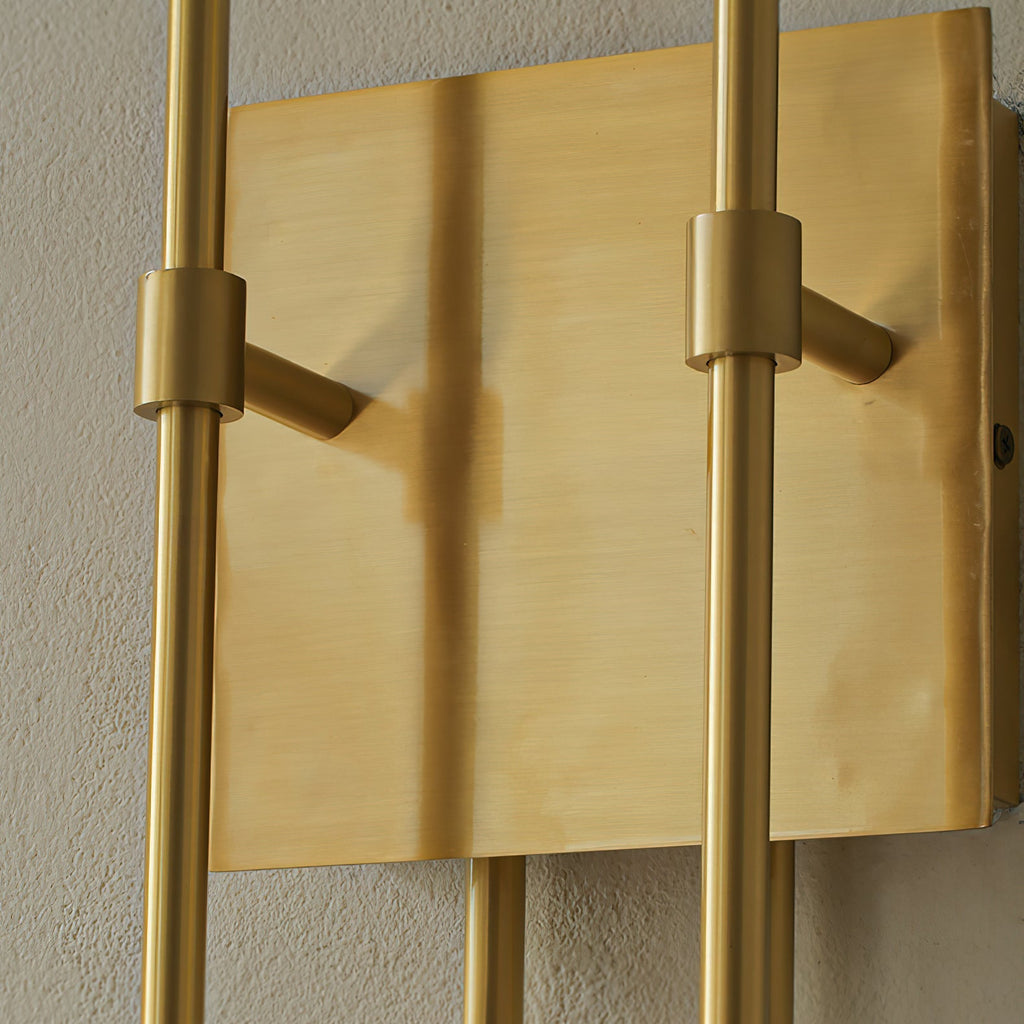 Close view of the brushed brass backplate and clamp collars holding the two upright arms of this Clérachic sconce.