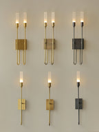 Six Clérachic sconces in a grid: three two-light and three single-light versions, in brass, antique brass and black, all lit on a beige wall.