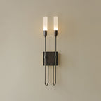 Dark black two-light Clérachic sconce on a plain beige wall, both frosted tubes lit above a square plate.