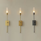 Three single-light Clérachic sconces side by side on a taupe wall, in brass, antique brass and black, each lit.