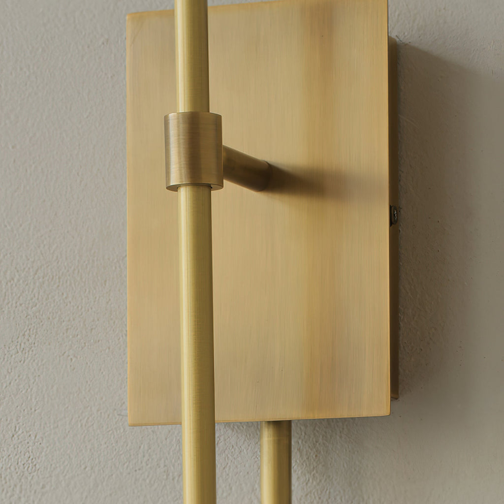 Close view of the brushed brass plate and a clamp collar on the upright arm of this Clérachic sconce.