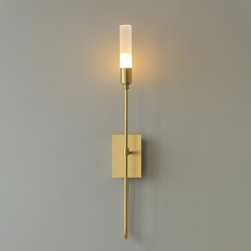 Single-light brass Clérachic sconce with a glowing frosted tube on a grey wall, a long straight arm below the plate.