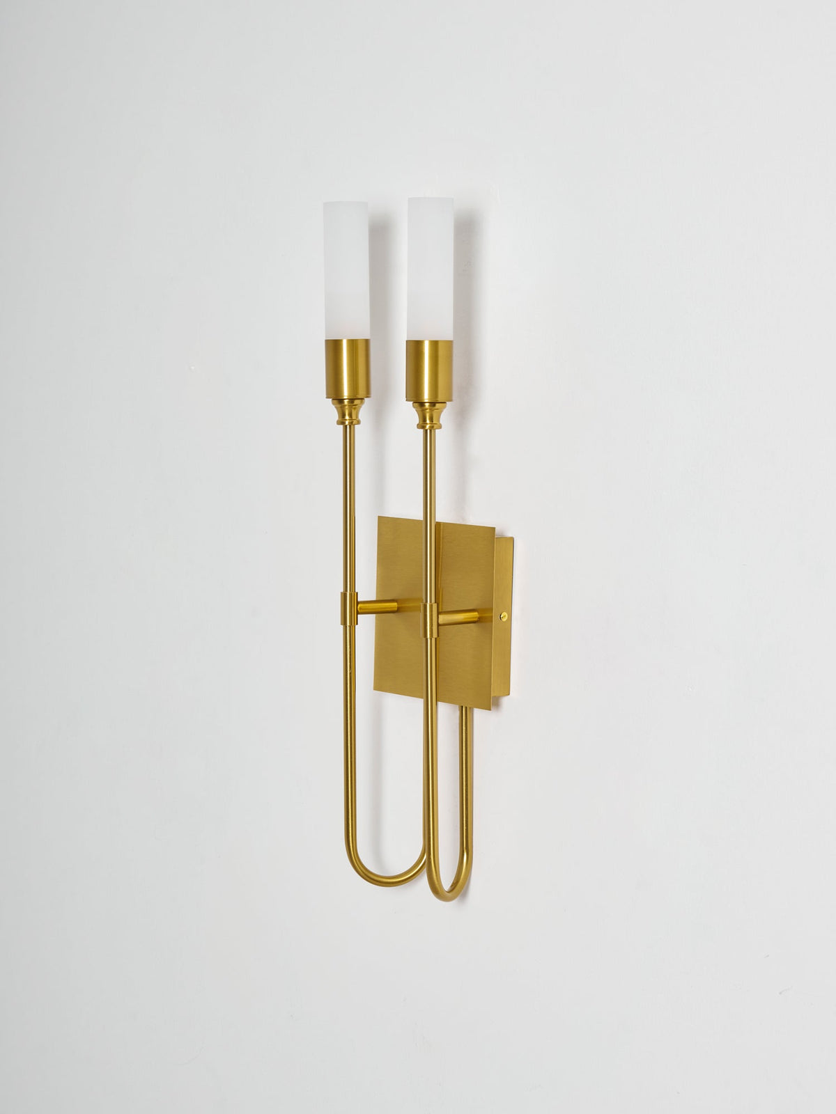 Side-on view of this brass Clérachic two-light sconce, showing how the arms and plate sit off a pale wall.