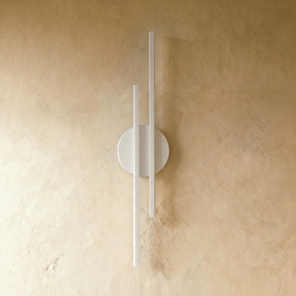 Clérachic wall light with two slim white bars on a round white backplate, switched off against a warm plaster wall