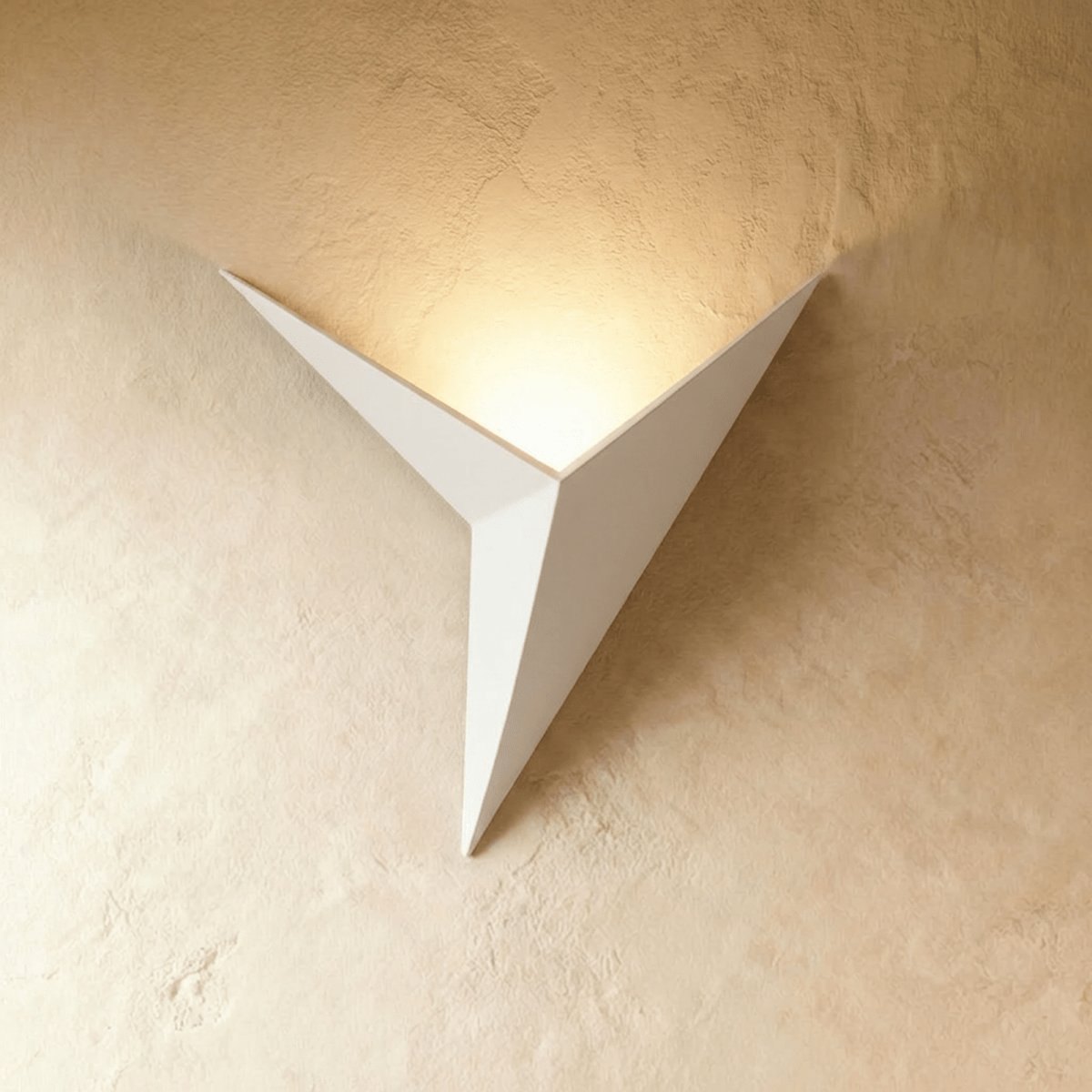 A Clérachic slim iron wall sconce in matte white casts a warm upward glow across a plaster wall corner.
