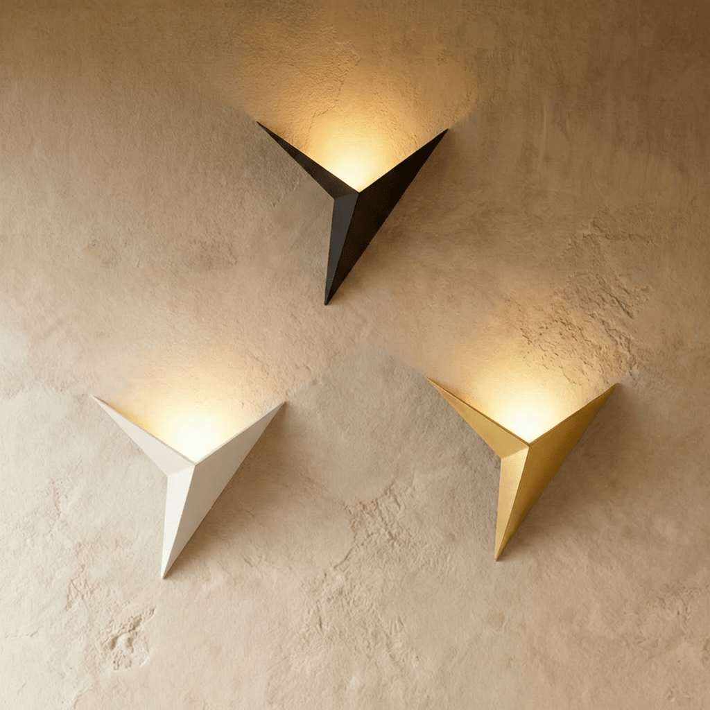 Clérachic slim iron wall sconces in black, white and gold finishes glow warm side by side on a plaster wall.