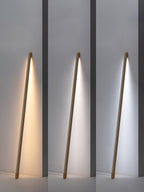 Three views of this Clérachic light wood floor lamp lit in warm, neutral and cool white, side by side on a grey wall.