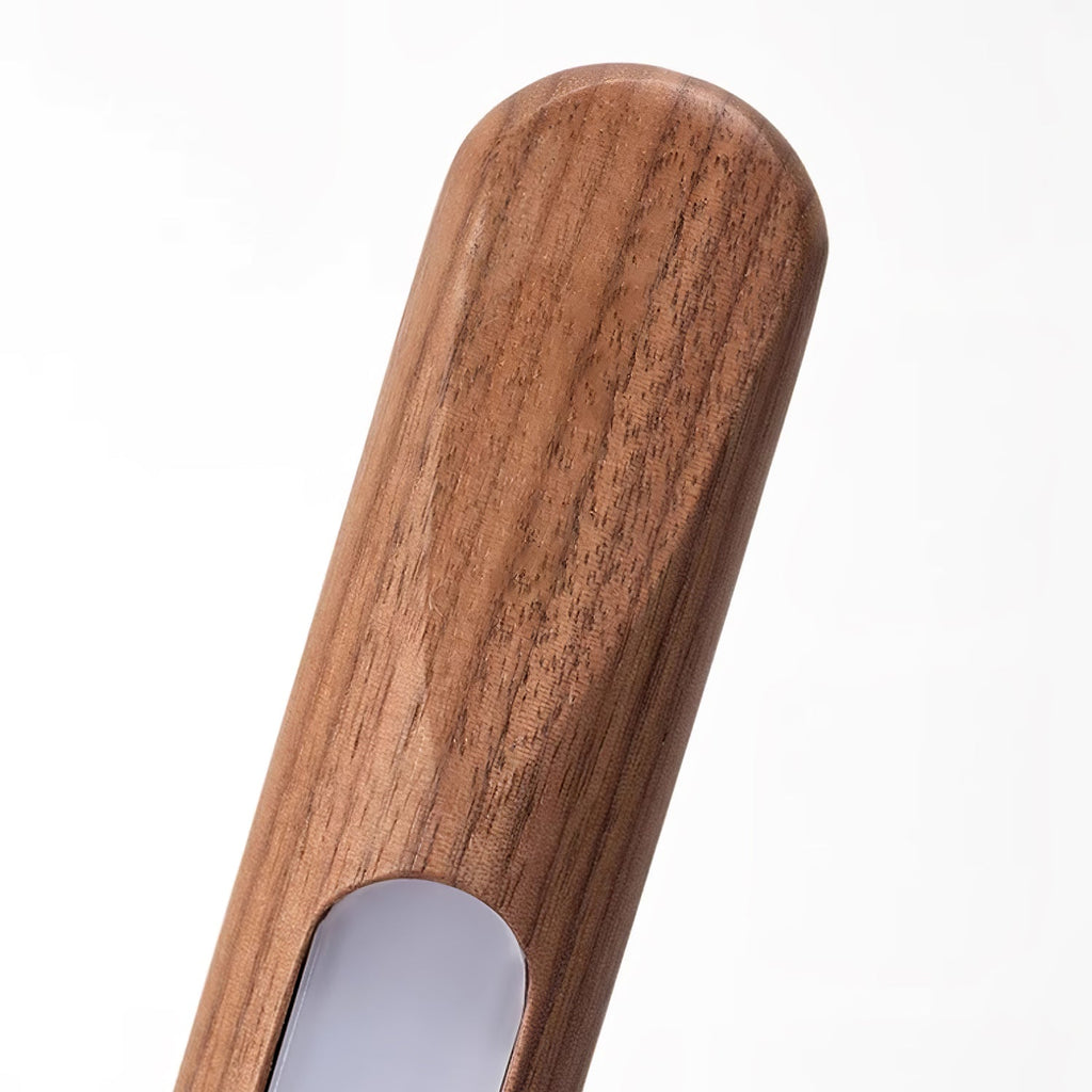 Close view of the rounded top of this Clérachic floor lamp, with walnut grain and the opening for the frosted light strip.