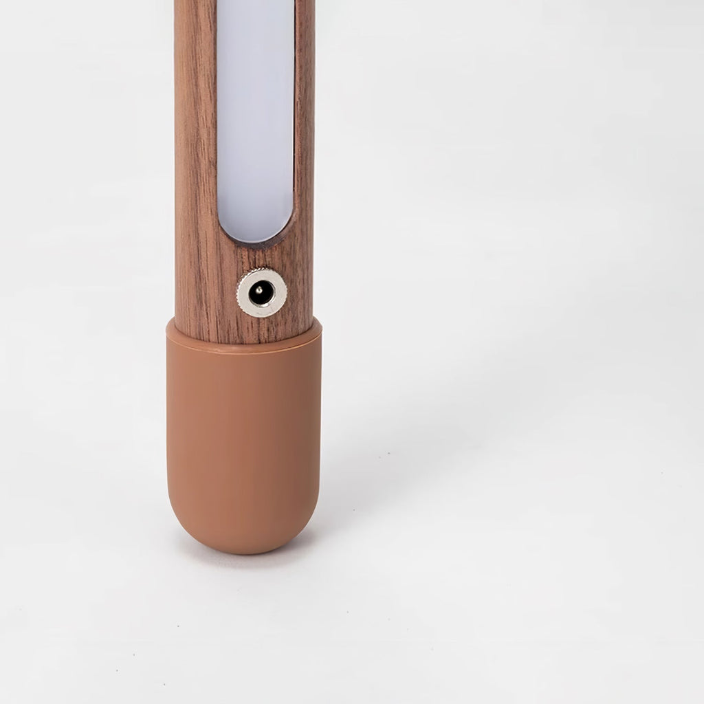 Lower part of this Clérachic floor lamp, showing the frosted light strip, a round power socket and the terracotta foot cap.