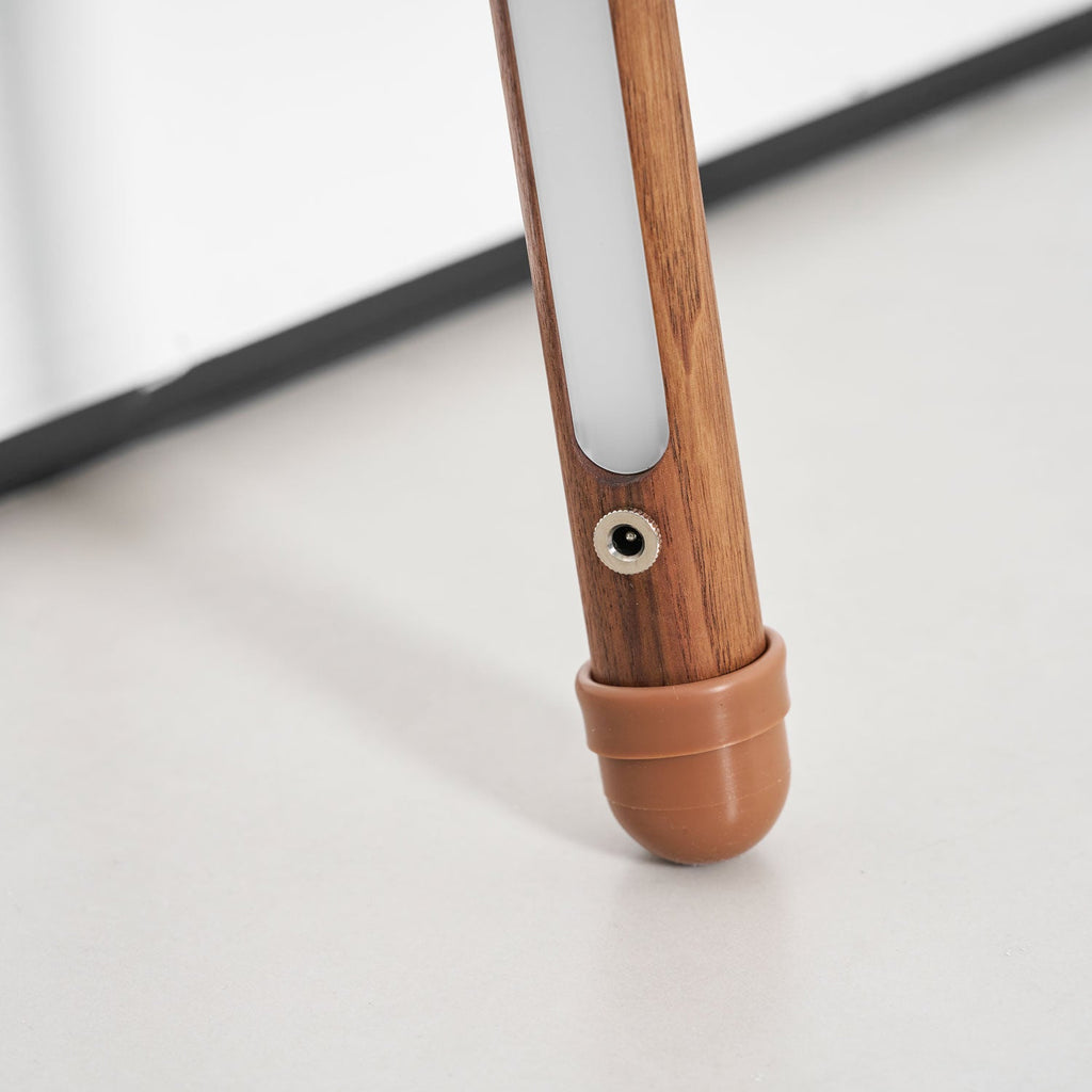 Close view of the foot of this Clérachic floor lamp, with the round power socket, light strip and a terracotta cap.