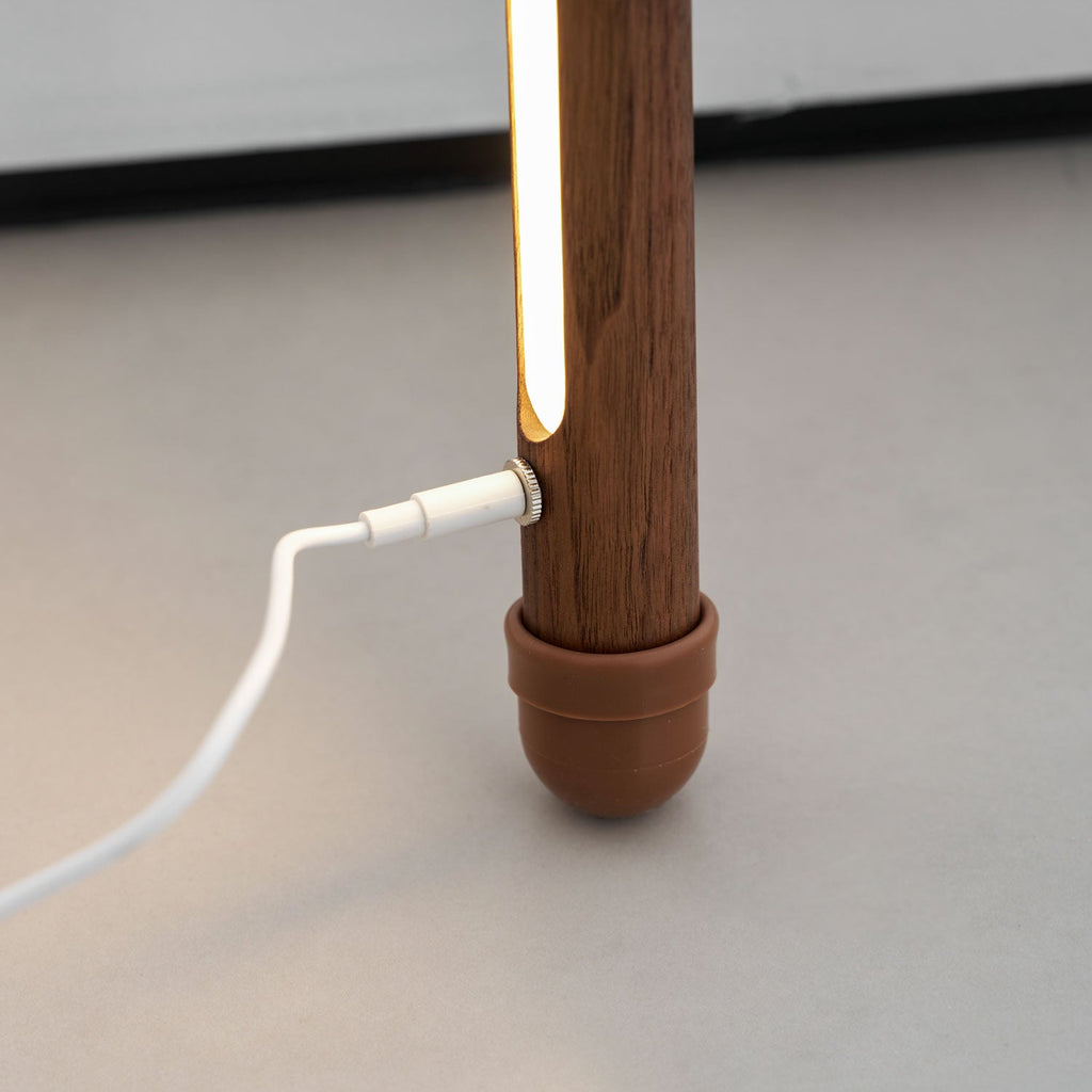 White power cable plugged into the side of this Clérachic floor lamp, just above its terracotta foot cap and light strip.