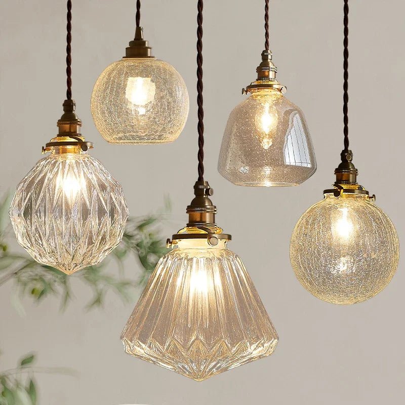Clérachic brass-finished pendant lights in five glass shades, faceted, crackled and bubbled, on twisted brown cords.