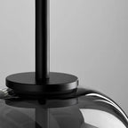 Detail of the Clérachic pendant's matte black stem and collar seated on top of the smoke gray blown-glass dome.
