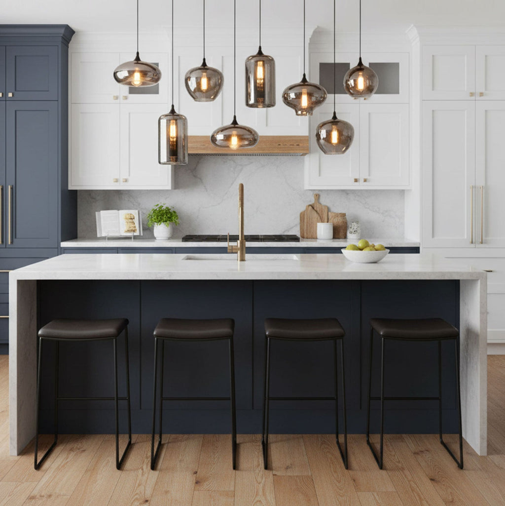 This Clérachic pendant's smoke glass shades hang above a white marble kitchen island with dark stools and a navy base.