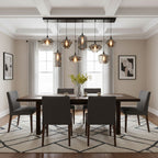 A Clérachic pendant with a black rectangular canopy lights a dining table in a cream room with a coffered ceiling.