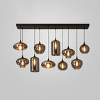 Ten smoke glass shades of varied shapes hang from the black canopy of this Clérachic pendant on a grey backdrop.