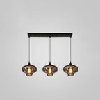 Three smoke glass shades with a narrow neck hang evenly from a black bar canopy on this Clérachic pendant.