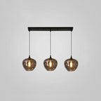 Three rounded smoke glass shades hang from a slim black canopy on this Clérachic pendant, glowing warm on grey.
