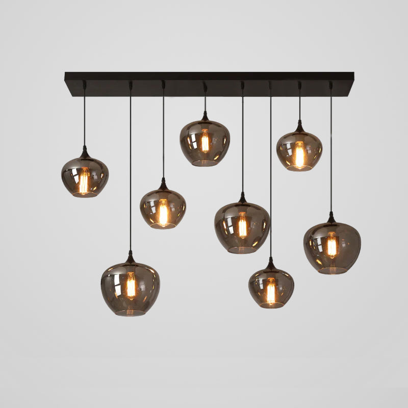 Eight smoke glass globes on this Clérachic pendant hang at uneven heights from a black bar canopy against grey.