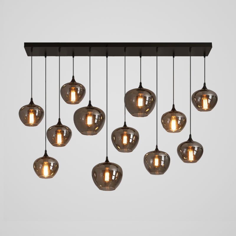 Twelve smoke glass globes of this Clérachic pendant hang from a long black canopy, arranged in a loose staggered pattern.