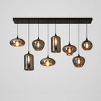 Eight mixed smoke glass shapes hang from a black canopy on this Clérachic pendant, with two tall cylinders among them.