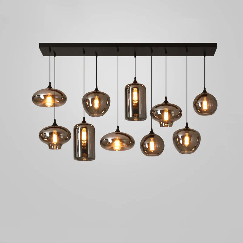 Ten mixed smoke glass shades, discs, globes and cylinders, hang from a black canopy on this Clérachic pendant.
