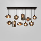 Ten mixed smoke glass shades, discs, globes and cylinders, hang from a black canopy on this Clérachic pendant.
