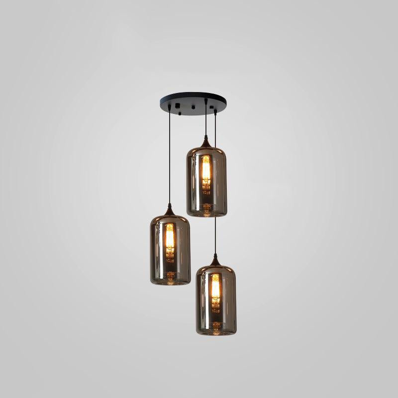Three tall smoke glass cylinders hang from a round black canopy on this Clérachic pendant, at three different drops.