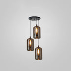 Three tall smoke glass cylinders hang from a round black canopy on this Clérachic pendant, at three different drops.