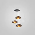 Three flat disc-shaped smoke glass shades hang from a round black canopy on this Clérachic pendant on grey.
