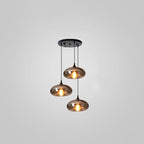 Three flat disc-shaped smoke glass shades hang from a round black canopy on this Clérachic pendant on grey.