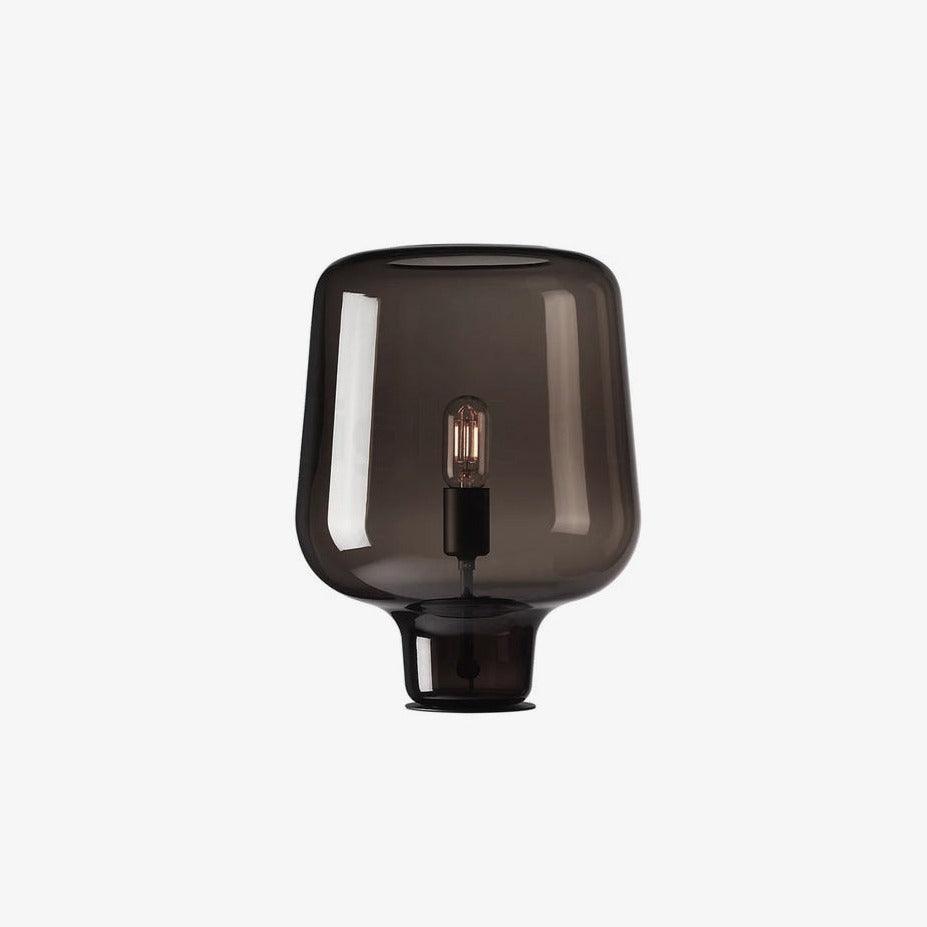 Smoke grey glass table lamp from Clérachic on a white backdrop, shown slightly smaller, with its black bulb holder inside.